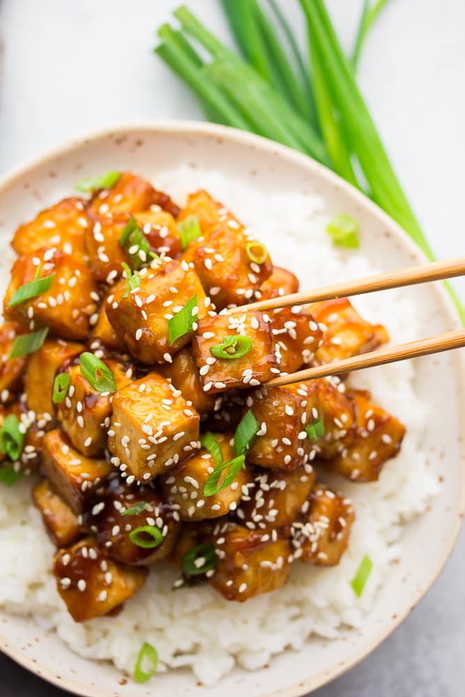 chopsticks grabbing tofu from bowl