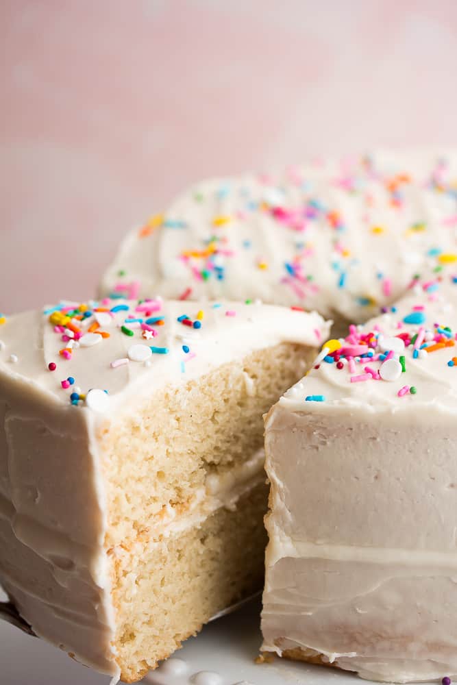 Close up of a slice of vanilla cake being removed from the cake