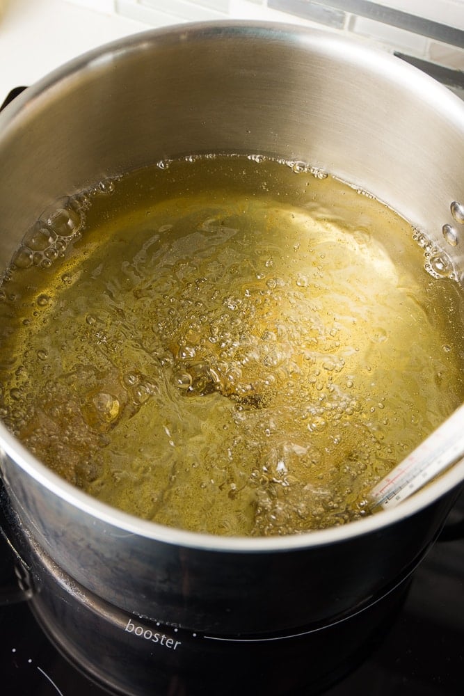 cheese sticks frying in oil in a big pot