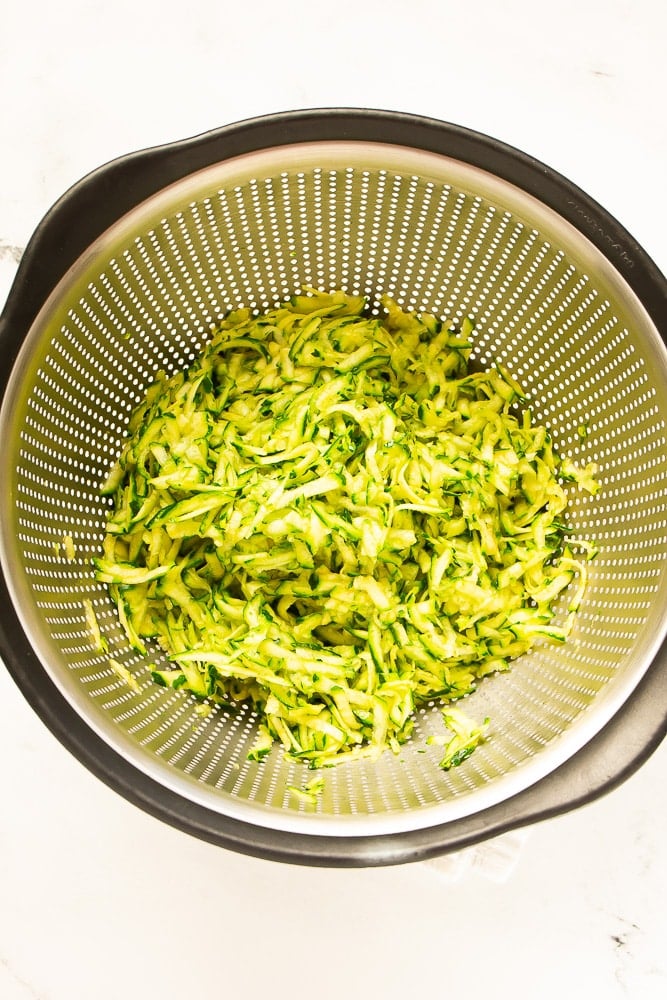 grated zucchini in strainer