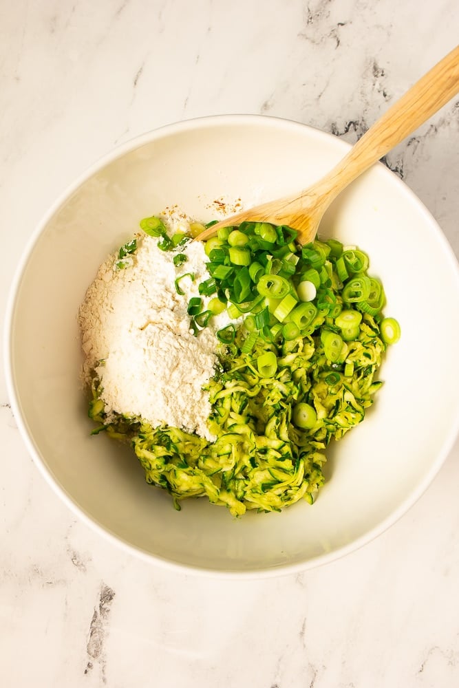 shredded zucchini and breadcrumbs in bowl with wooden spoon