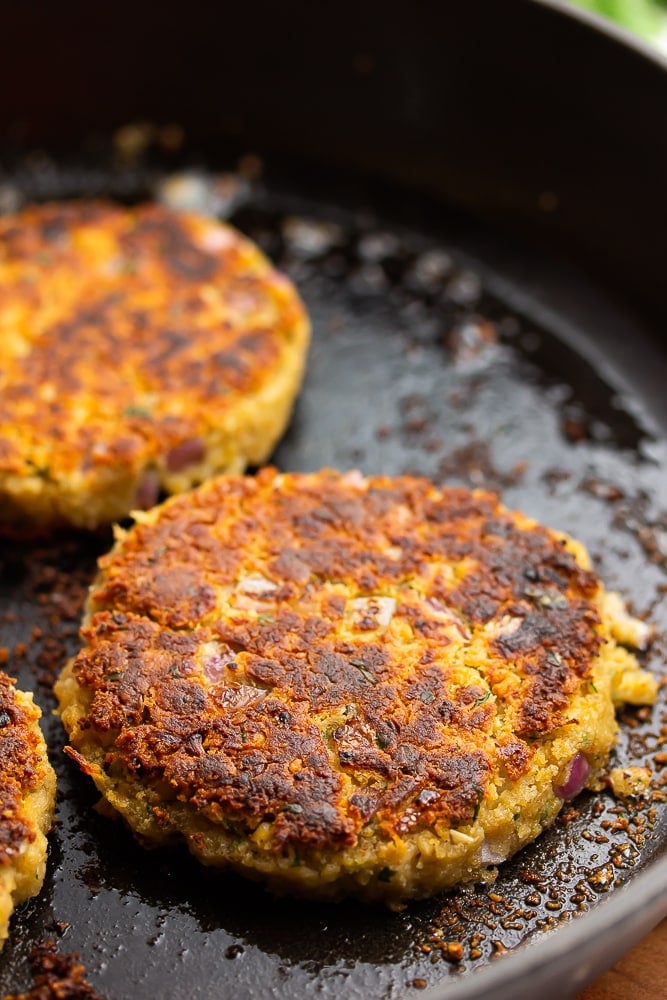 cast iron pan with burgers in it, that look vegetarian bean based