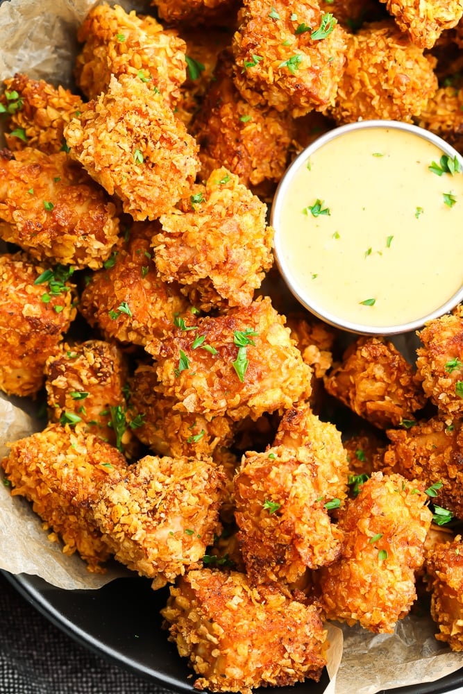 looking down on lots of vegan chicken nuggets with yellow sauce