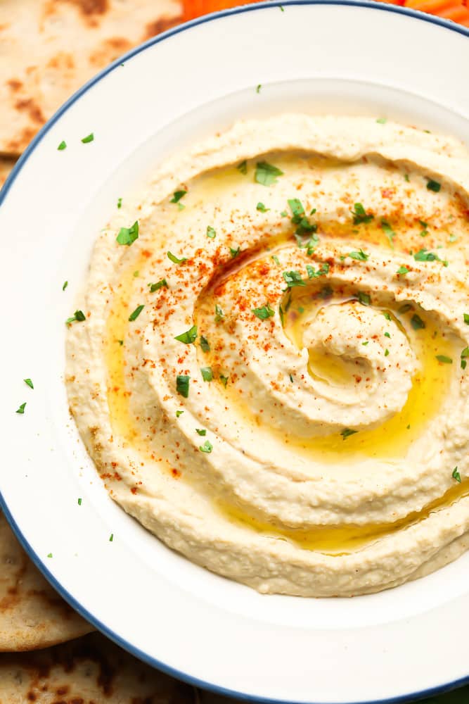 bowl of creamy dip with green sprinkled parsley and paprika