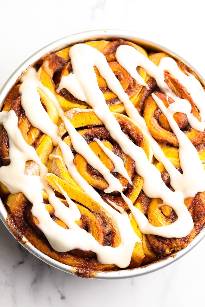 glazed pumpkin rolls in a round metal dish