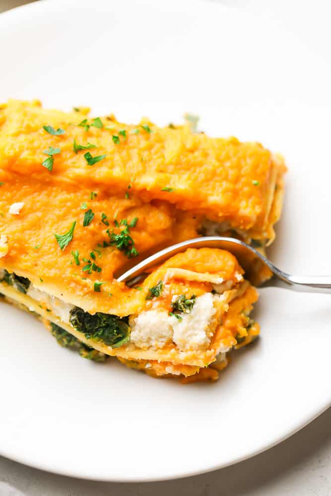 close up of a fork taking a bite of butternut squash lasagna