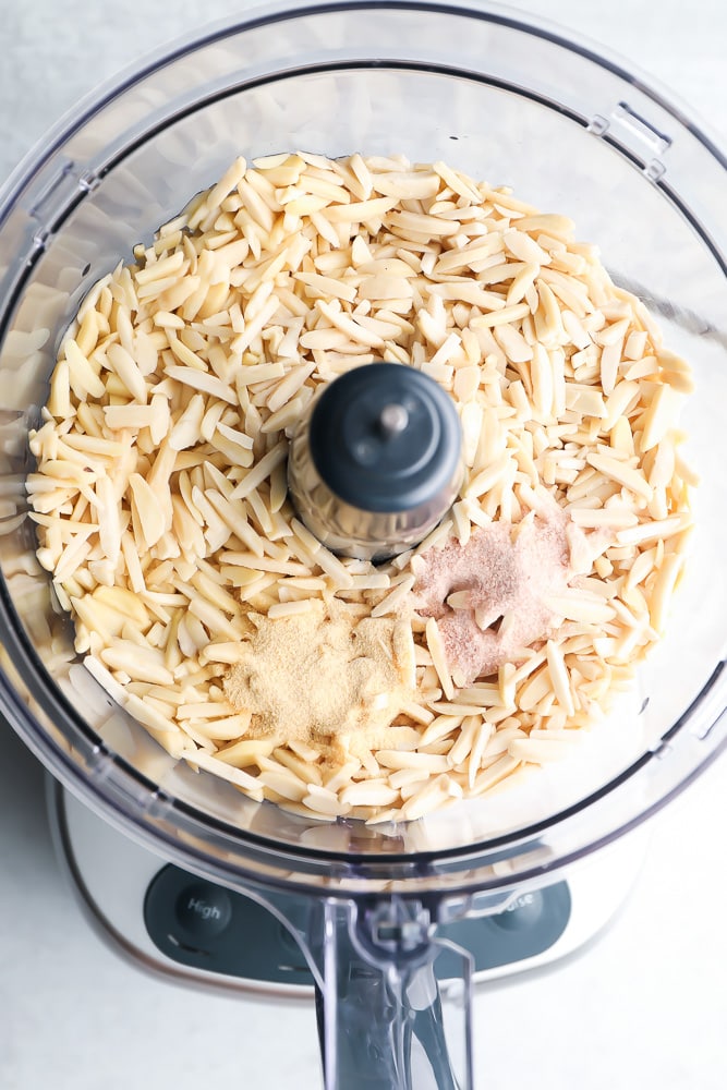 raw slivered almonds and spices in a food processor, whole
