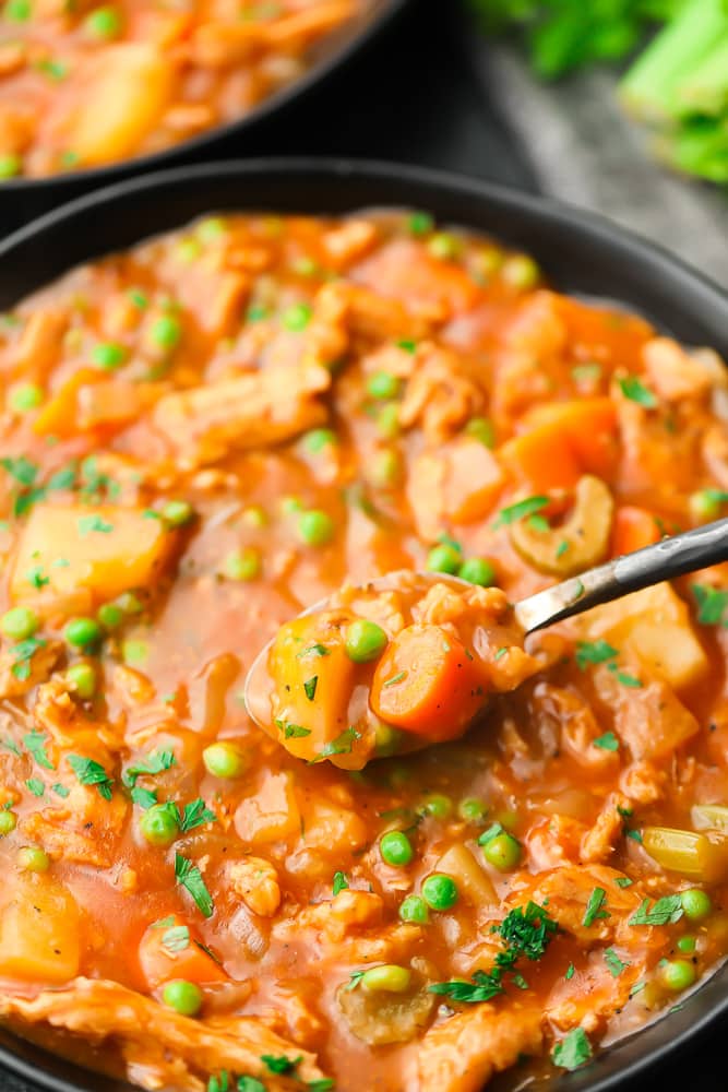 spoonful of stew from a black bowl