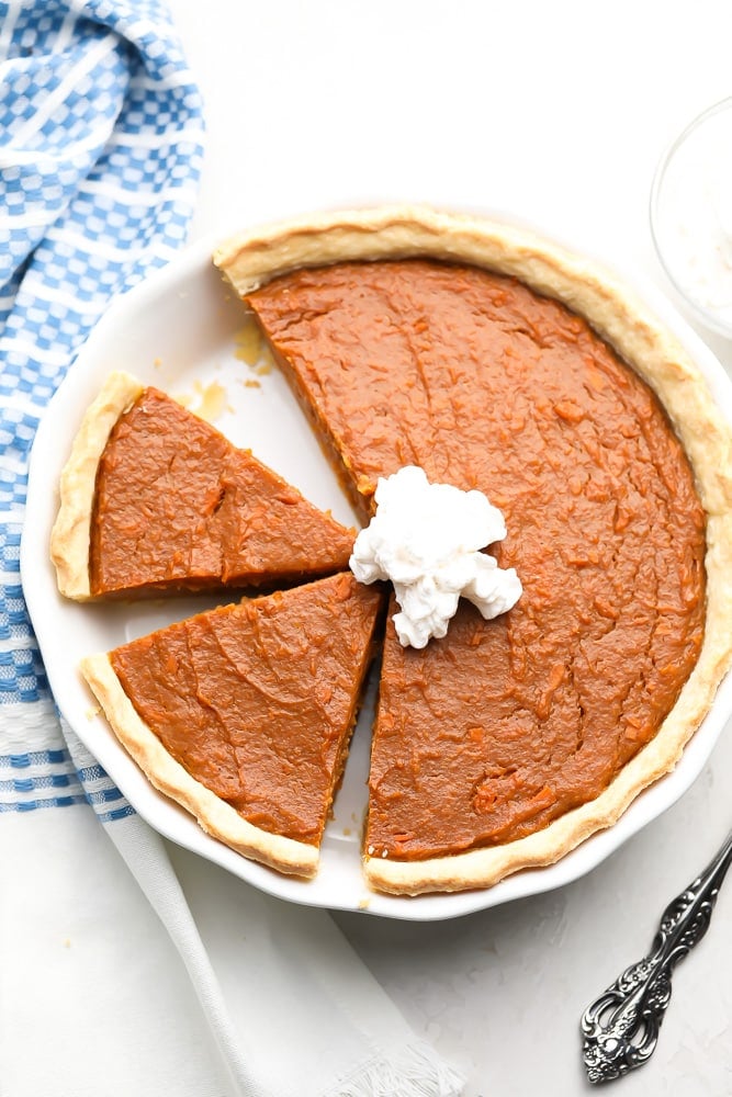 looking down on a pie with slices in it, blue towel and white background