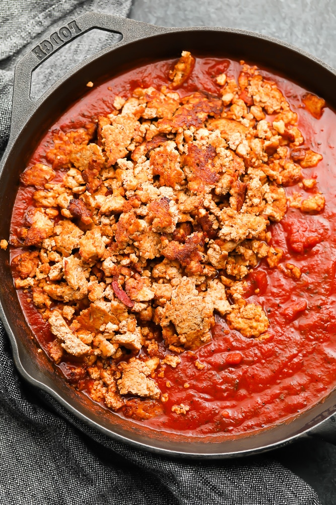 cast iron pan with marinara sauce and tofu crumbles