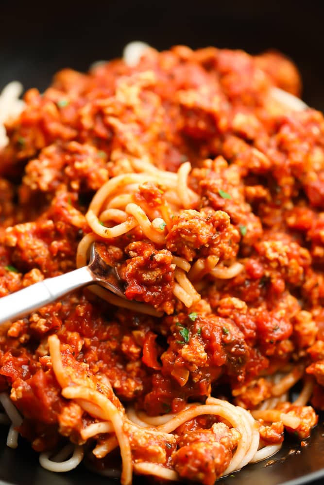 fork full of pasta with sauce on it