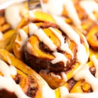 square image of a pumpkin cinnamon roll lifting out