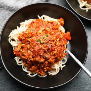 square image of a bowl of pasta with meaty looking sauce on top
