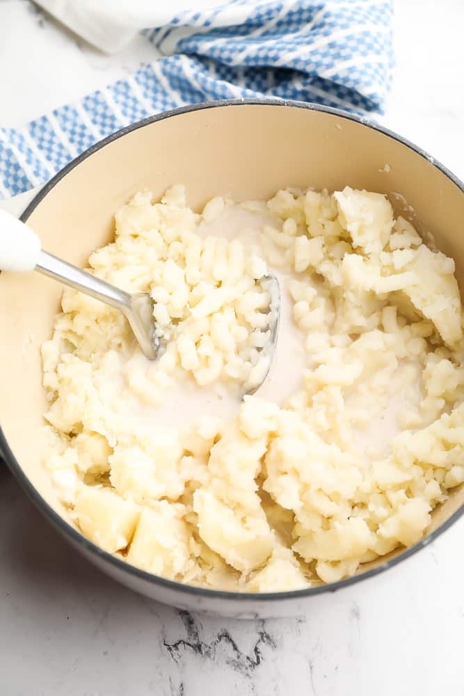 mashing potatoes in pot