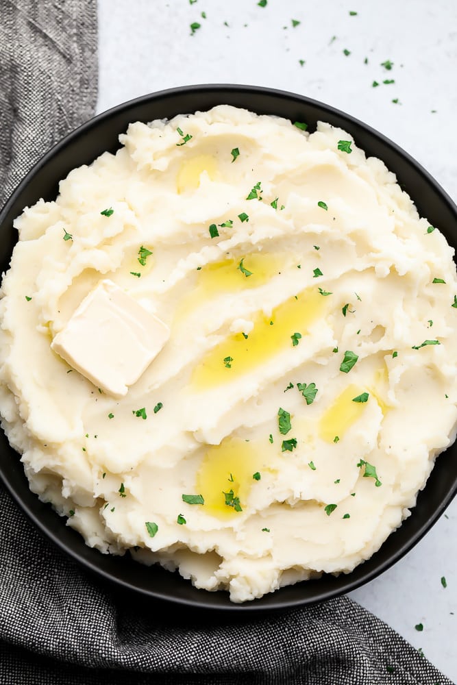 black bowl full of mashed potatoes with butter