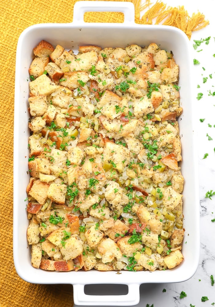 cooked vegan stuffing in a large dish with a yellow towel under it.