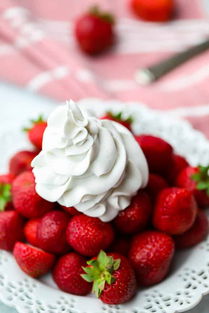 whipped cream on strawberries on a plate