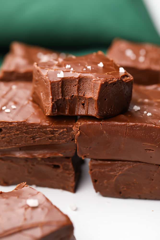 stacks of fudge with green towel in background, bite taken out of one piece