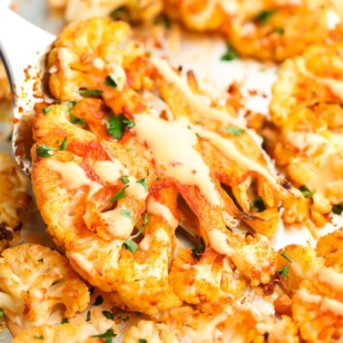 square image of cauliflower steak being lifted off pan