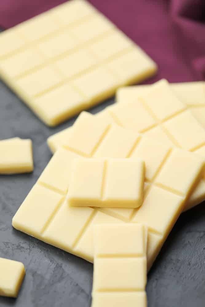 many broken pieces of white chocolate, laying on top of each other