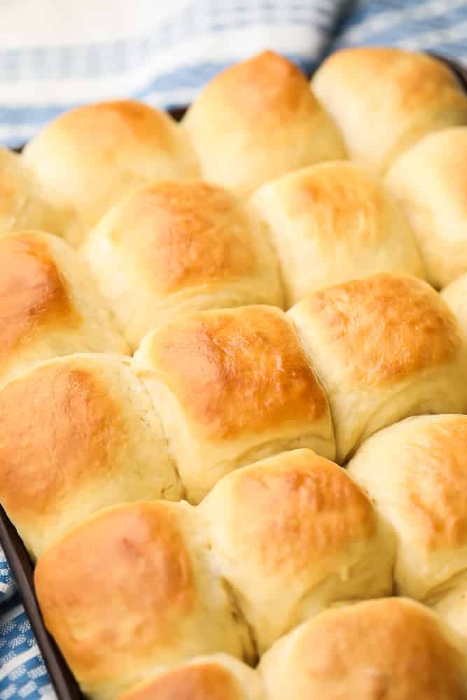 pan full of cooked vegan dinner rolls, blue towel background