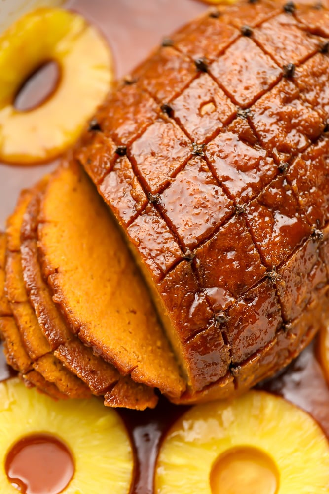 looking down on a roast, sliced with pineapple rings around it