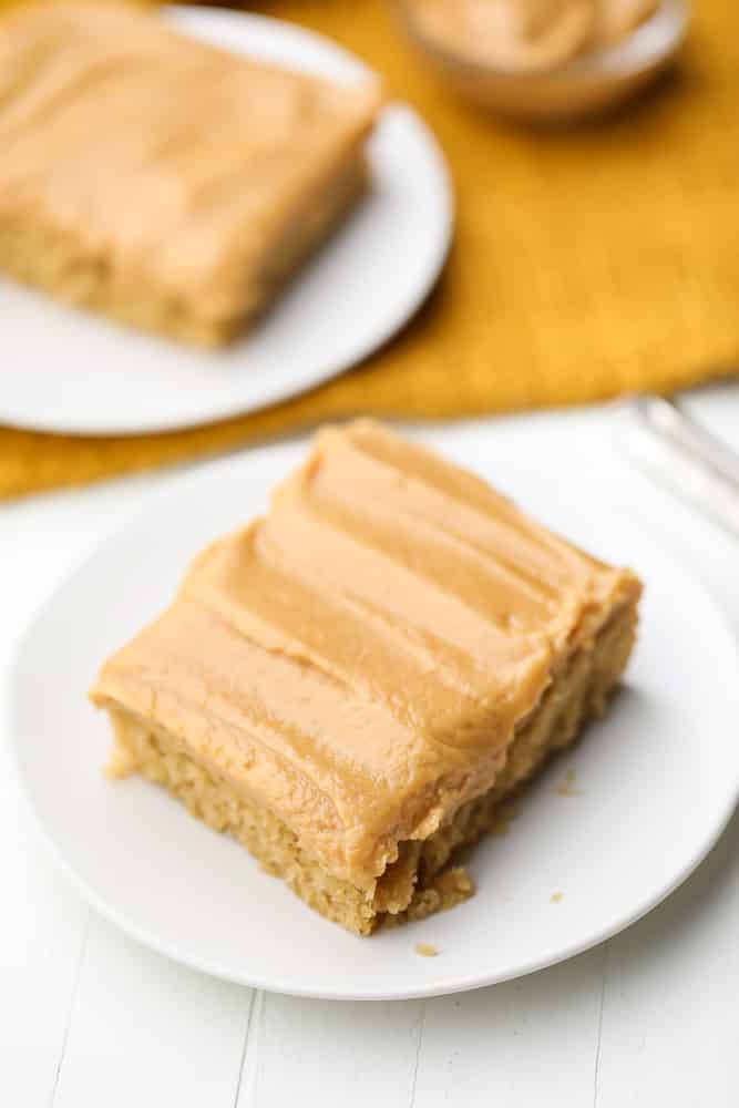 peanut butter cake on a white plate, a slice with more in background