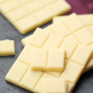 square image of white chocolate, burgundy towel in background