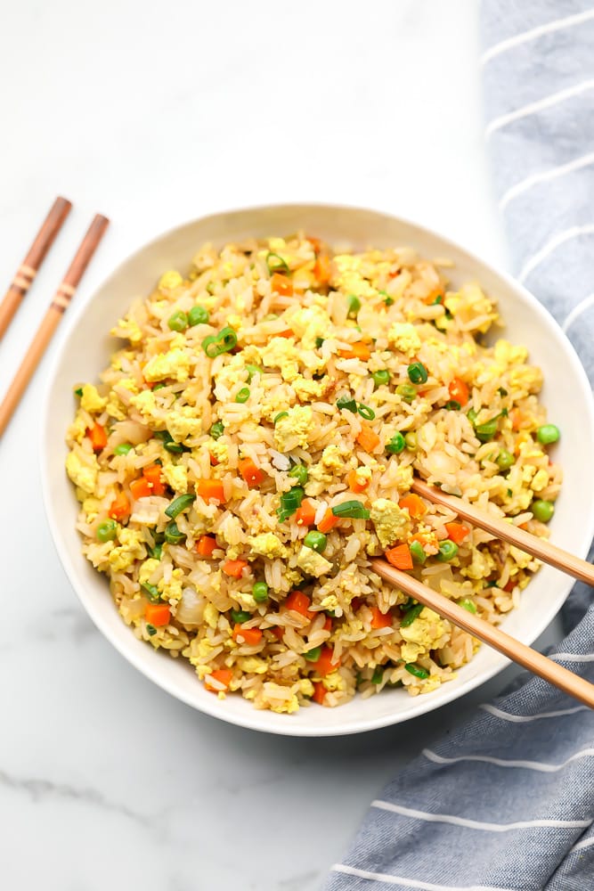 bowl of fried rice with chopsticks, white background