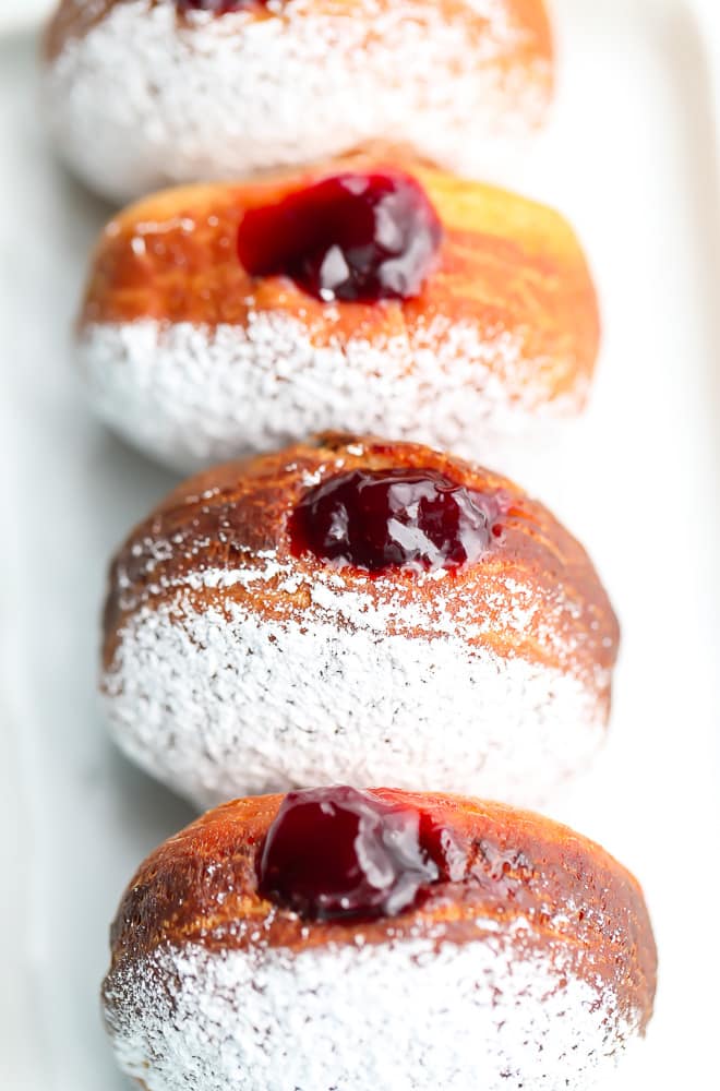 straight row of powdered sugar donuts