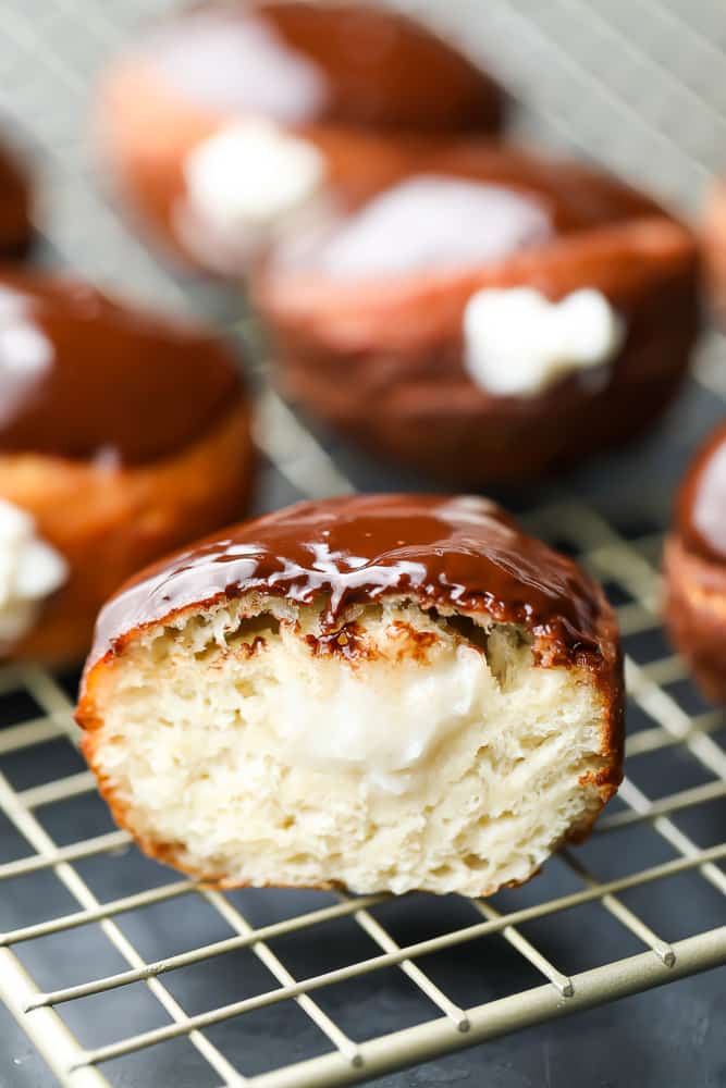 cut open boston cream donut on rack, more in back