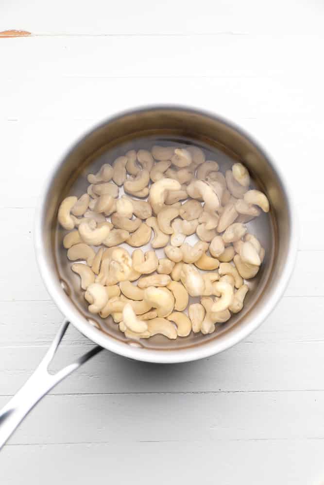 cashews being soaked in a small pot