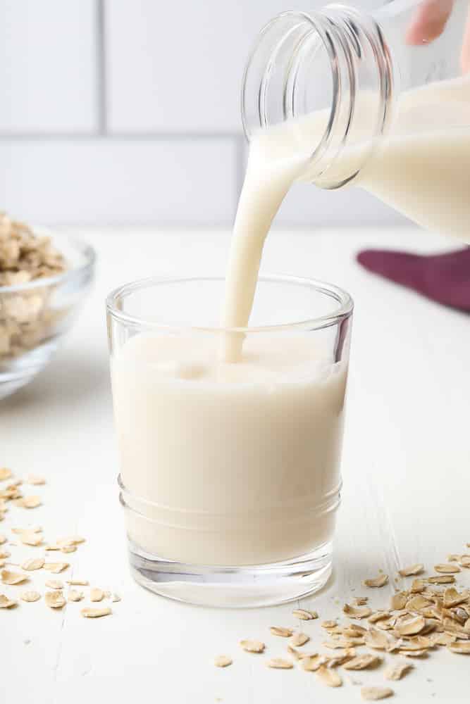 oat milk being poured into a glass