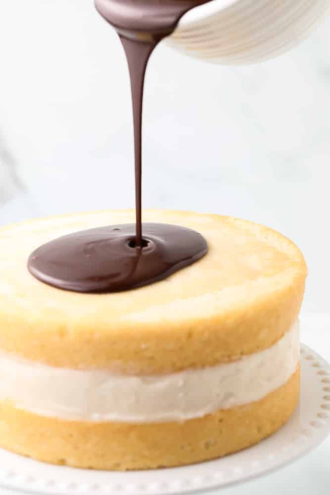 ganache being poured onto cake