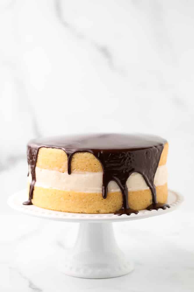 marble backdrop of cake with ganache and cream filling