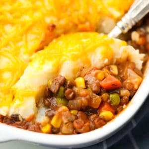 square image of a casserole with cheddar mashed potatoes on top