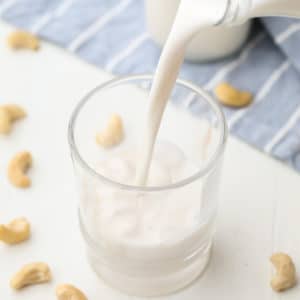 square image of a glass of milk being poured into a cup