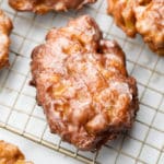 square image of an apple fritter on cooling rack