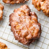 square image of an apple fritter on cooling rack