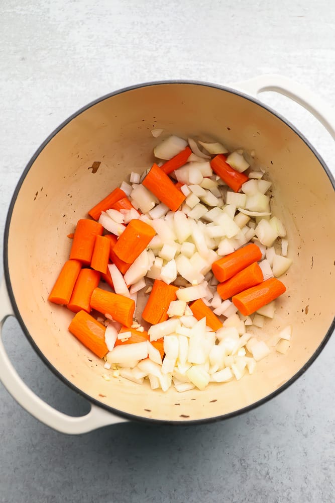 Large pot with raw onions and carrots