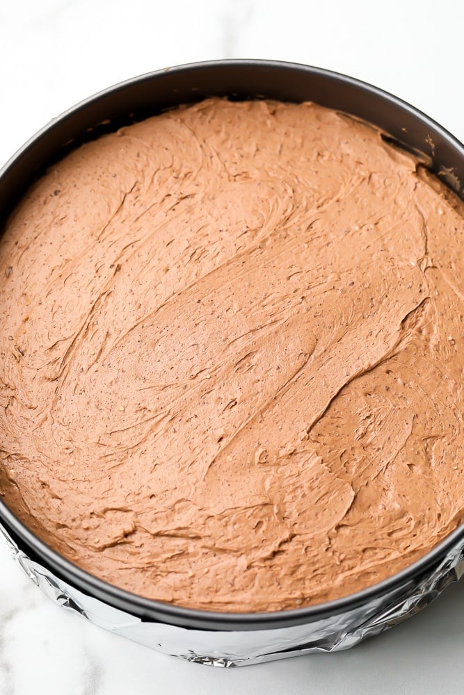 Raw chocolate cheesecake filling in a metal pan