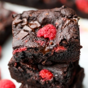 square image of a brownie with raspberries in it