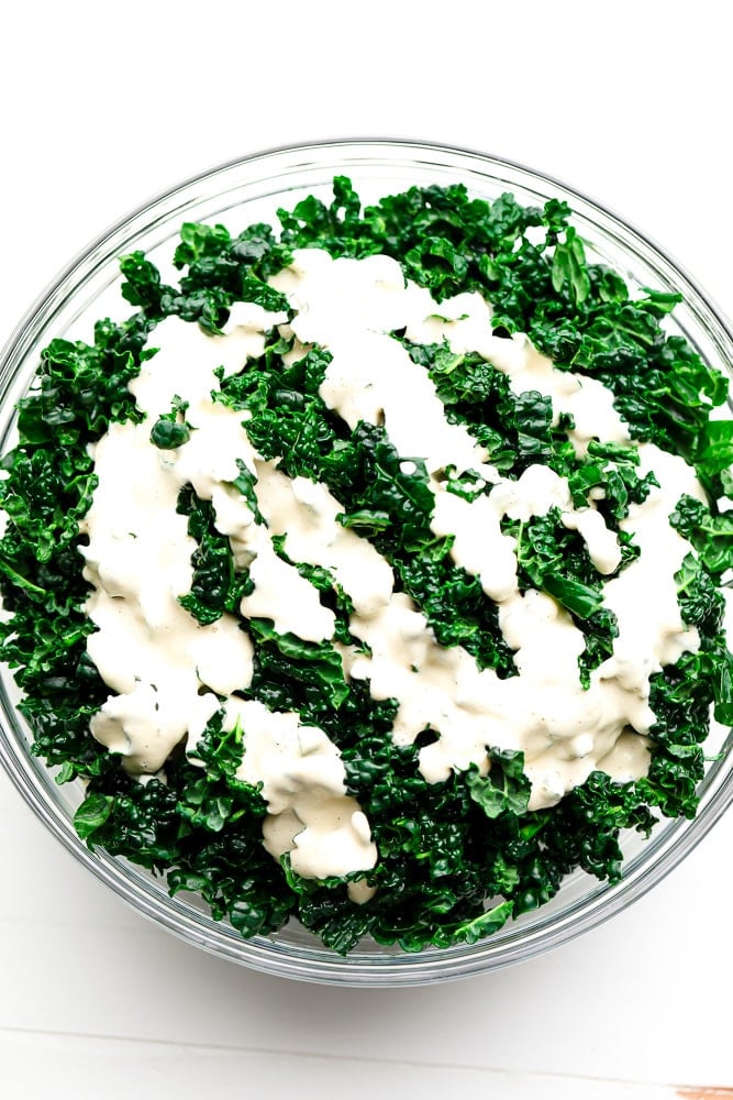 kale in a bowl with white dressing on top