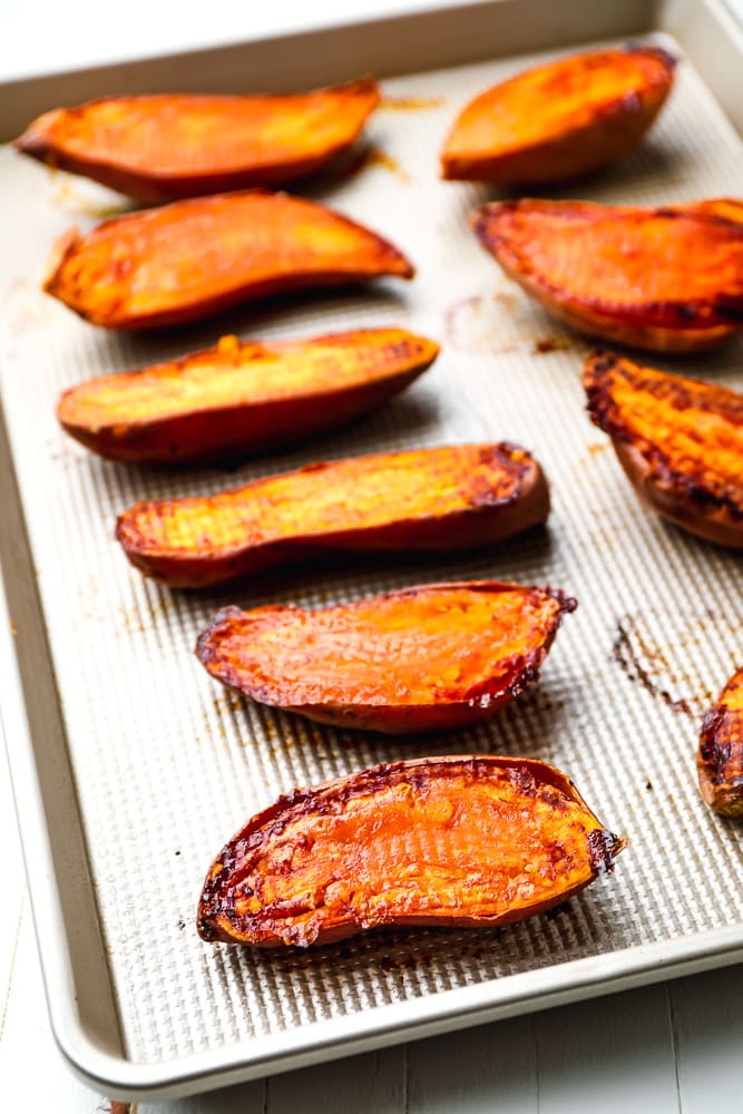 baked sweet potatoes flesh side up on a baking sheet