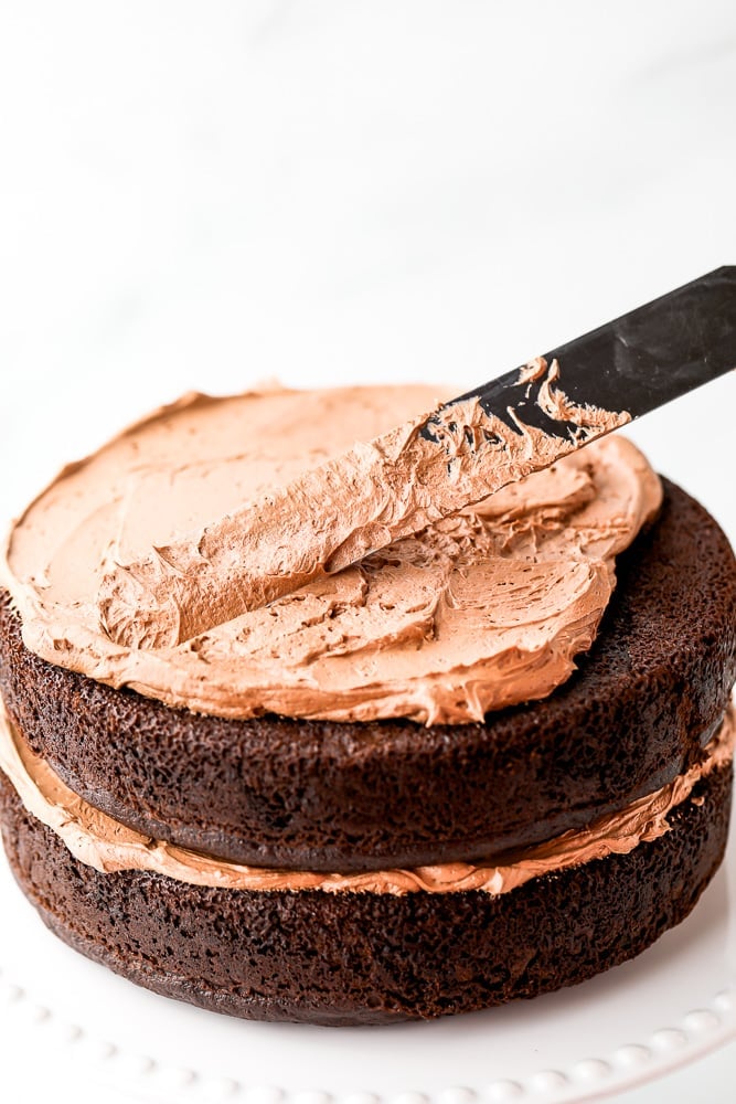 frosting a chocolate cake with chocolate frosting