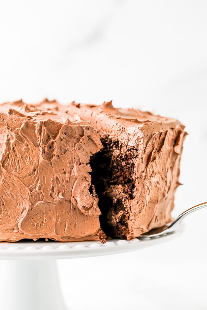 spatula removing a slice of chocolate frosted cake