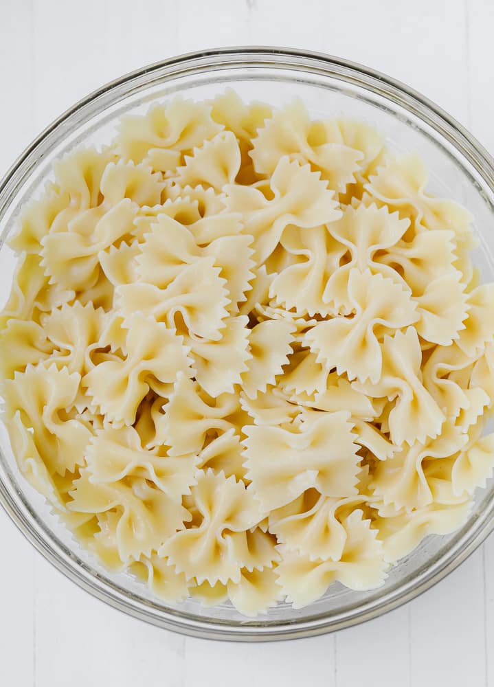 glass bowl filled with cooked bow tie pasta