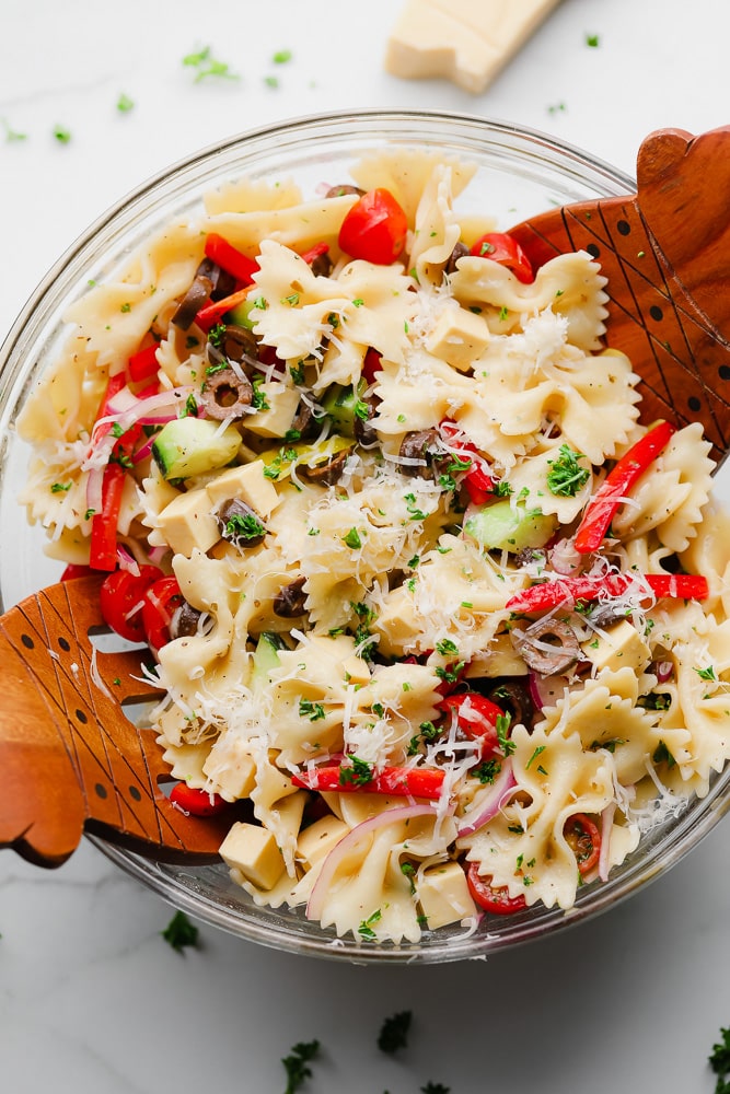 wood salad tongs mixing a pasta salad together