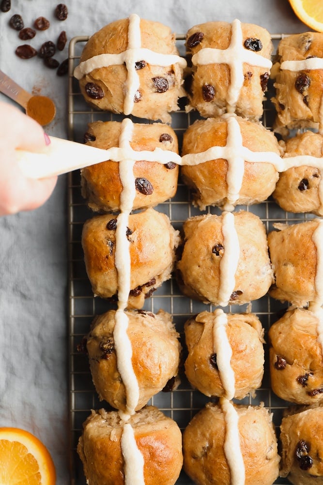 icing being piped onto rolls in cross like shapes