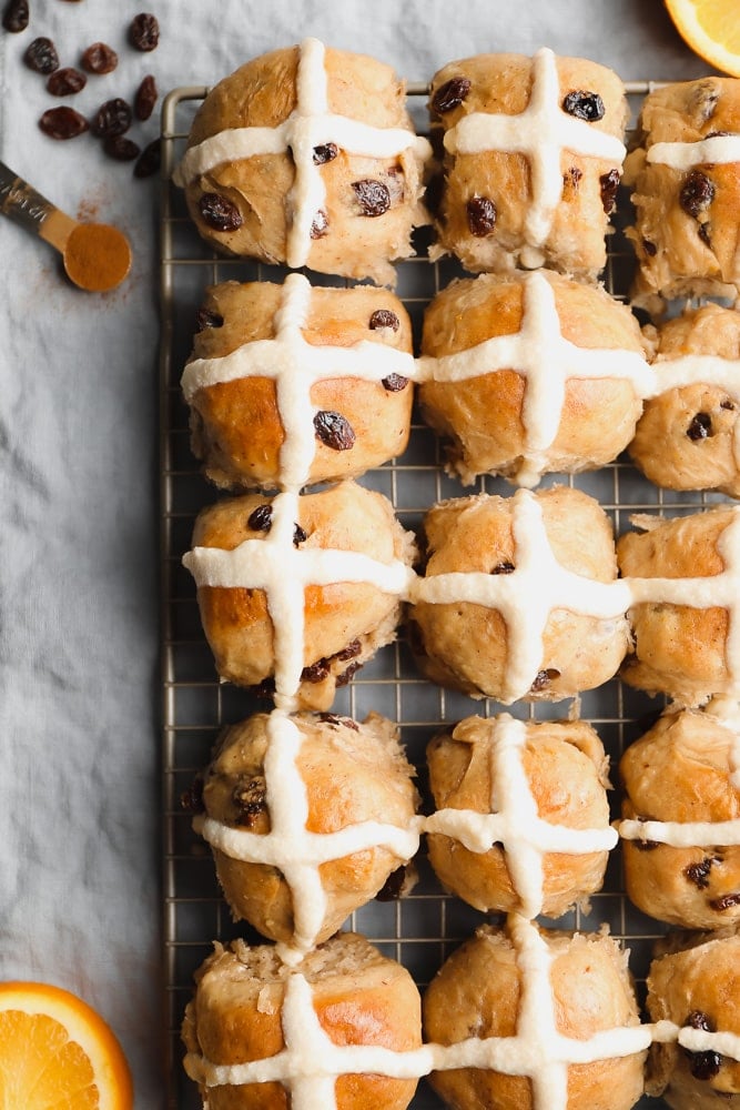 many rolls with cross icing on a cooling rack